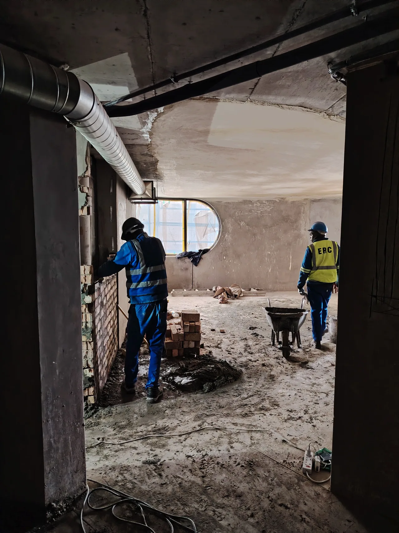 Two construction workers building an interior at The Cole Hotel